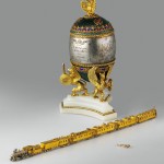 Osterei mit dem Modell eines Sibirien-Zuges (659 KB) Sank Petersburg, 1900, Meister: M. Perchin Gold, Platin, Silber, teilweise vergoldet, Diamanten in Rosenschliff, Rubin, Onyx, Kristall, Holz, Seide, Samt, Email auf guillochiertem Grund, Filigran- Email Ei: H. 26 cm, Zug: L. 39,8 cm, Waggon: H. 2,6 cm